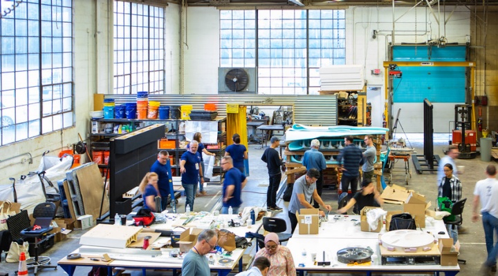 Wide view of the main open workshop space with students and teachers engaging in making ceramics. 