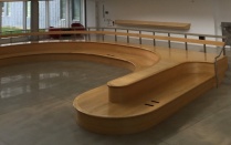 Large curving wooden bench. 